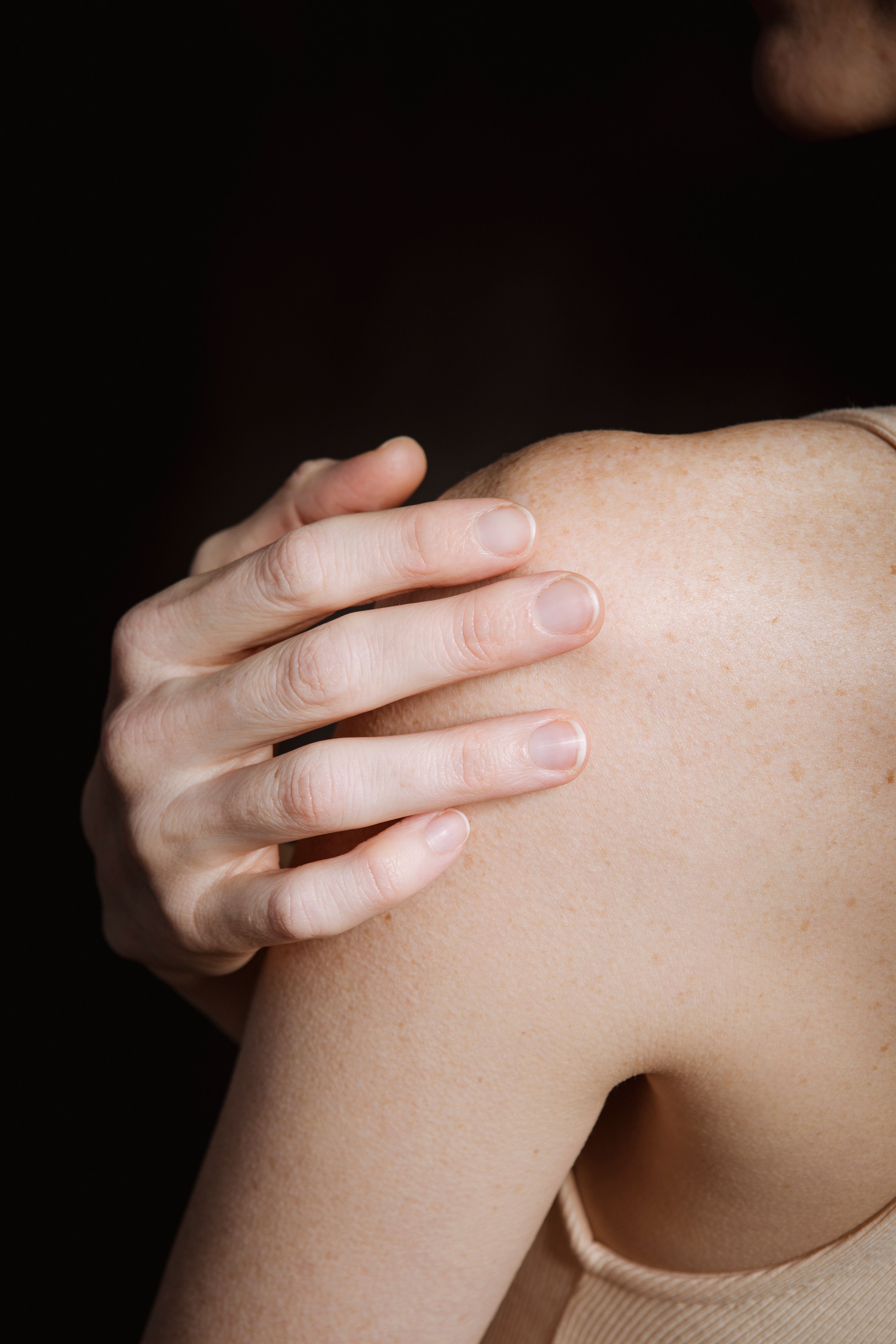 A woman touching her shoulder | Source: Pexels