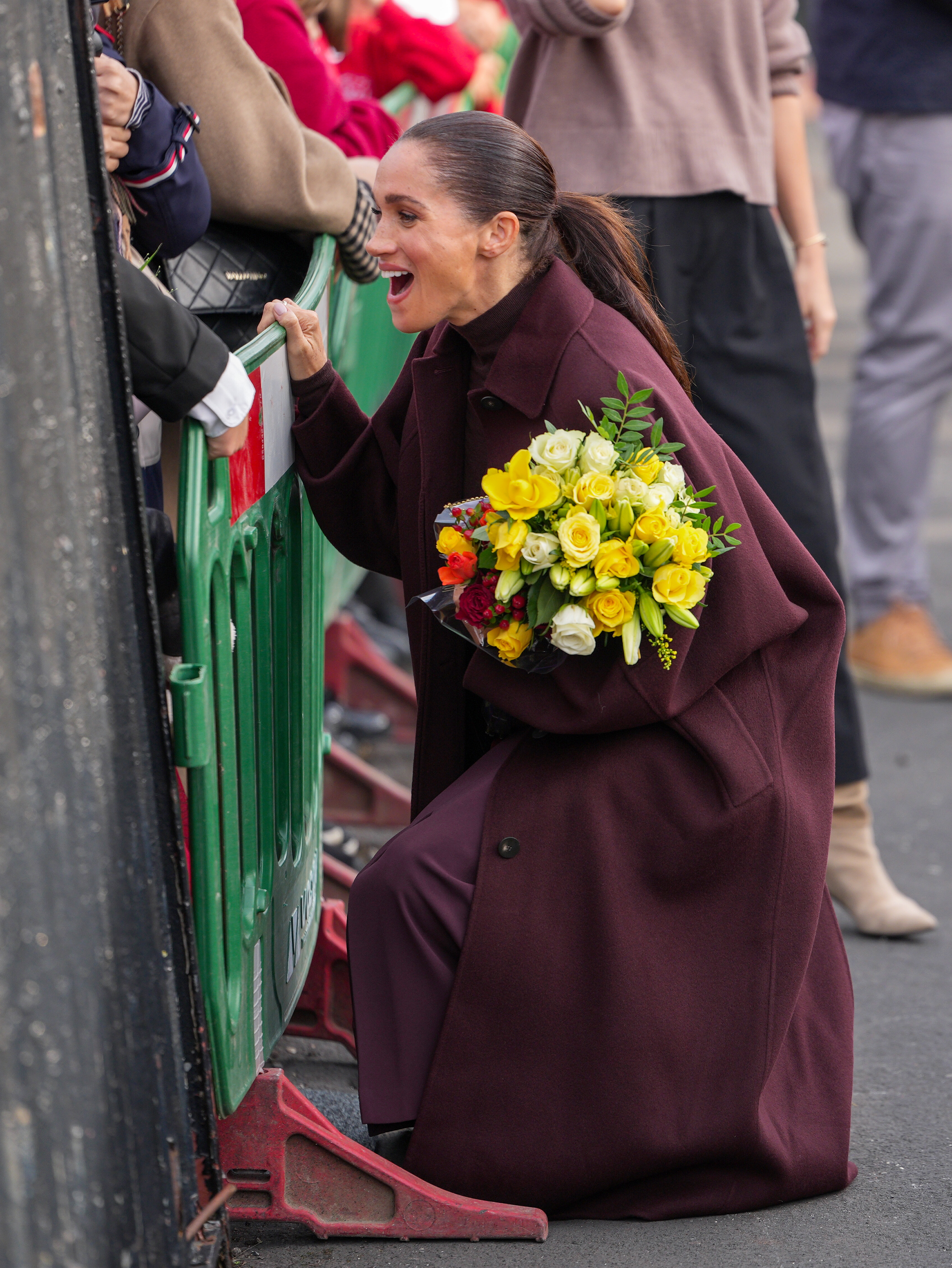 Meghan, Duchess of Sussex, holds a bouquet of flowers and greets well-wishers as she arrives at the Community Recording Studio (CRS). | Source: Getty Images