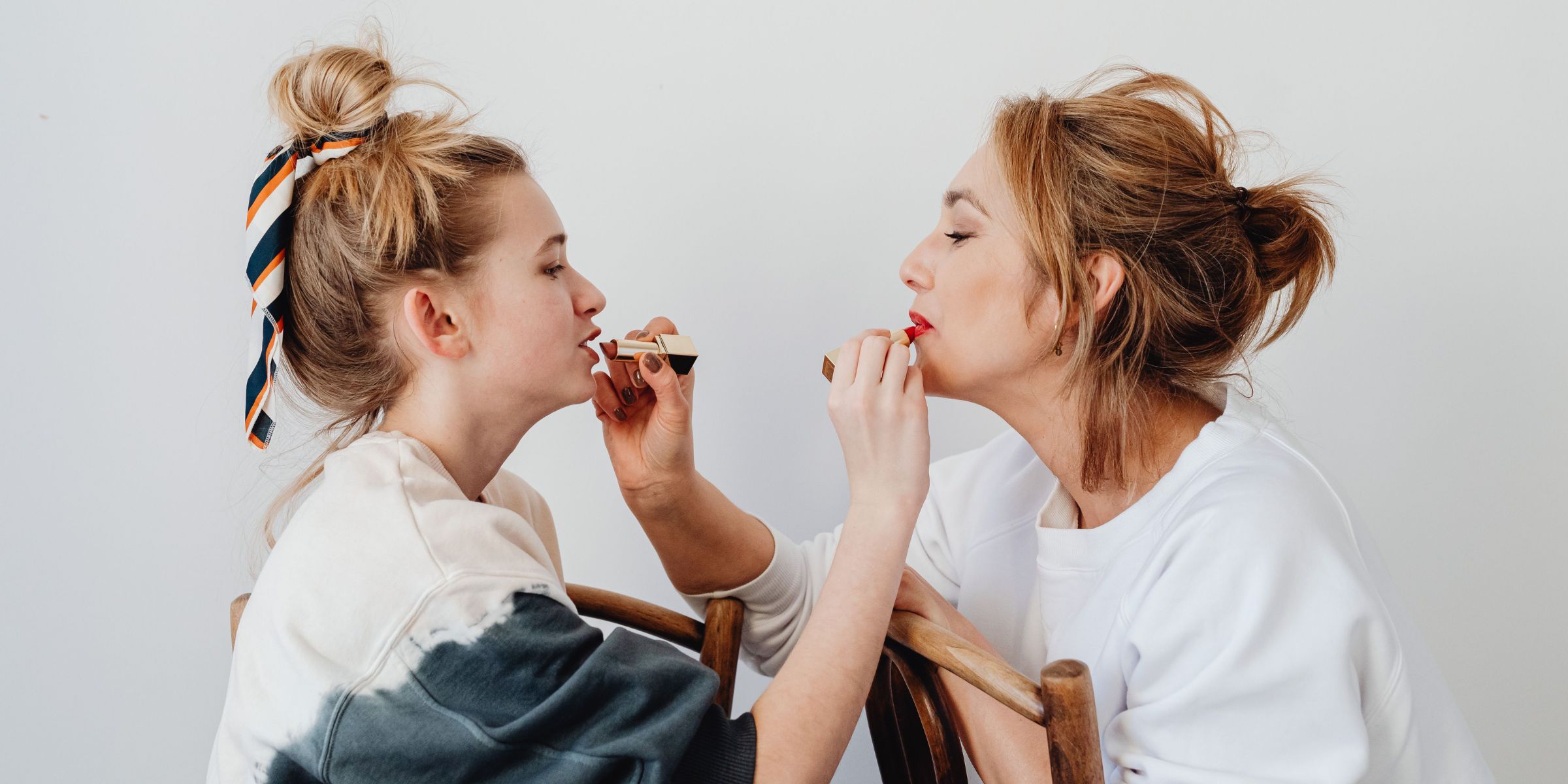 Two women applying lipstick on each other | Source: Pexels
