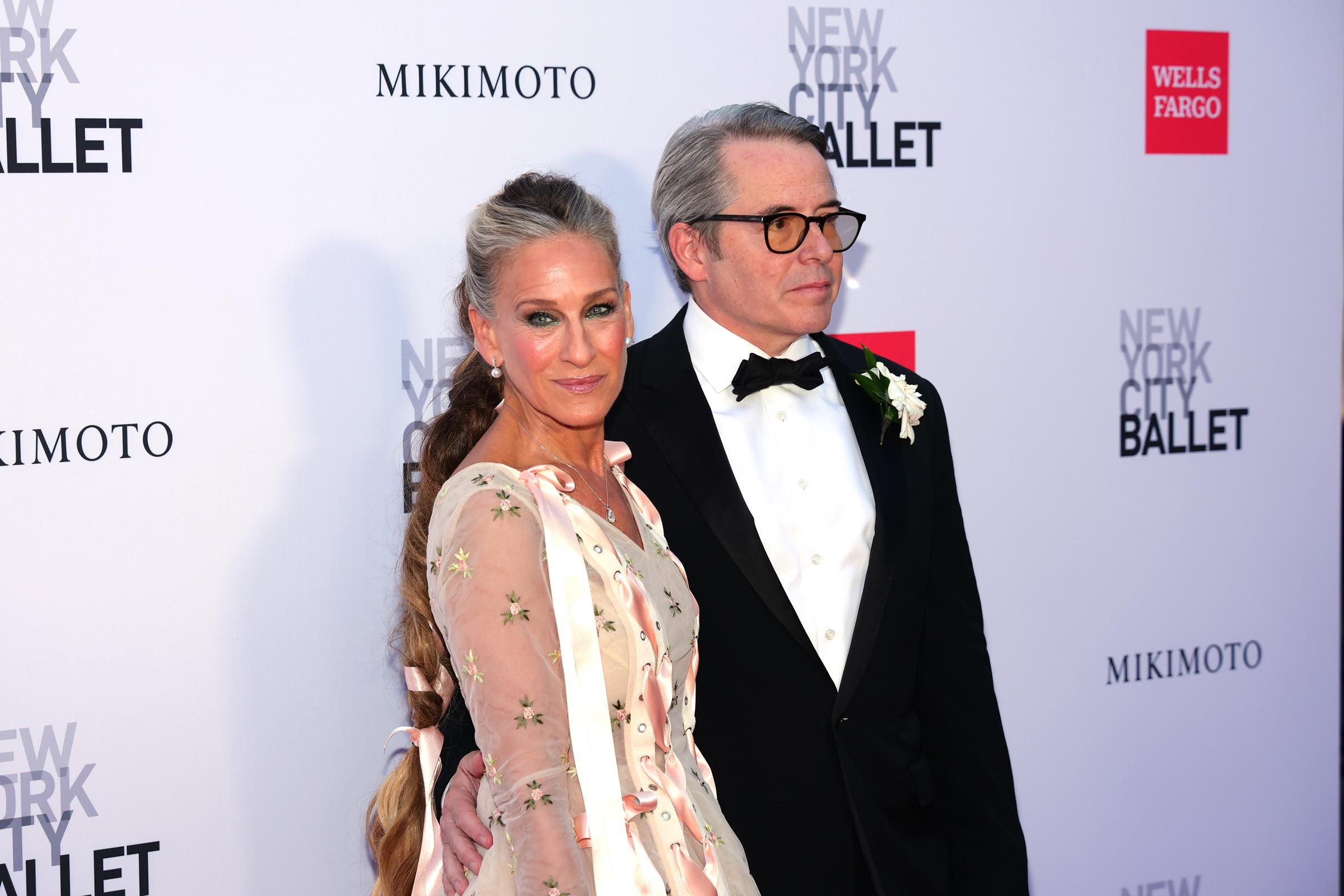 Parker turns toward the cameras beside Broderick, revealing how the pale pink ribbons on her dress continue into her dramatically long, ribbon-woven braid. | Source: Getty Images