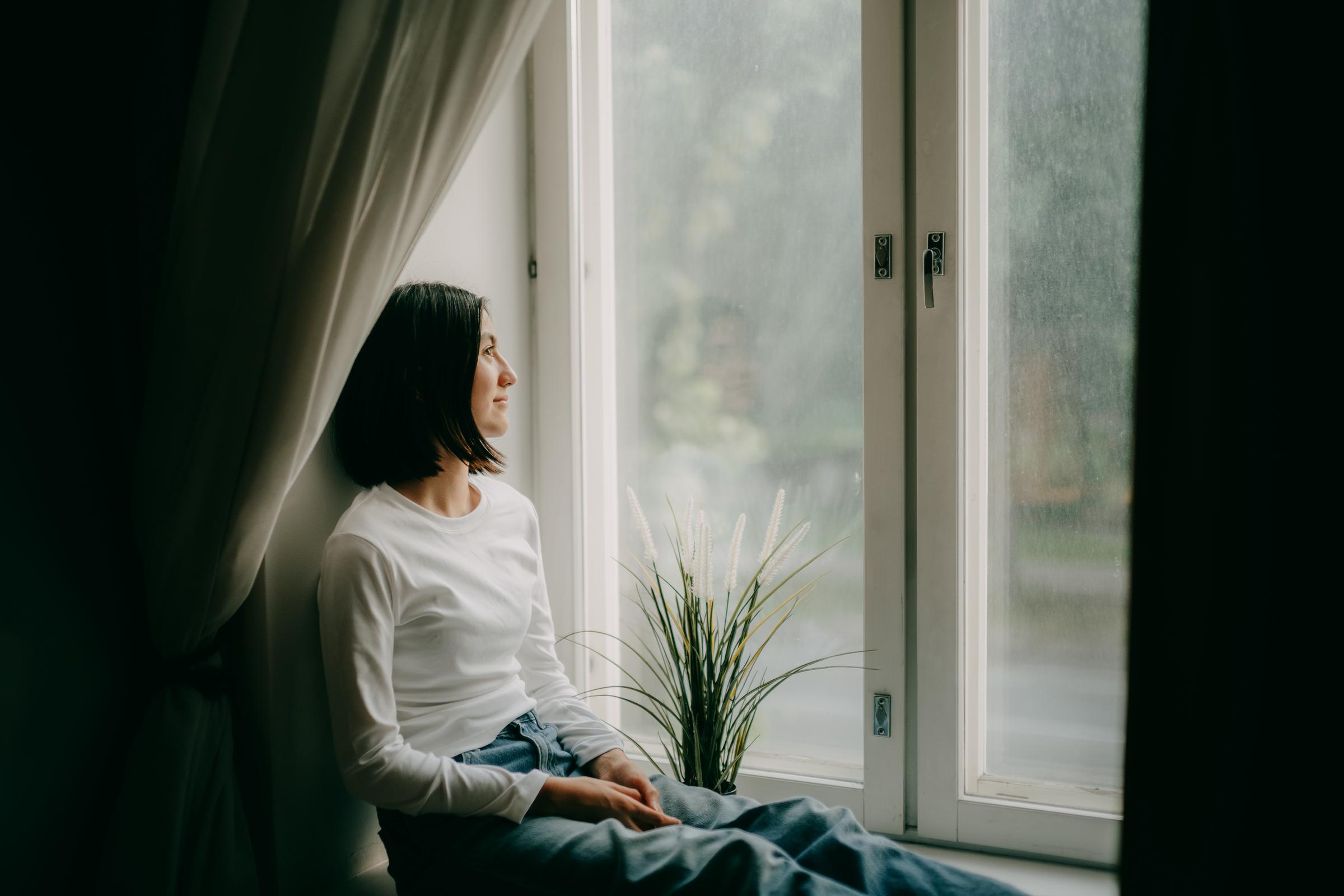 A young girl relaxing by a window | Source: Getty Images