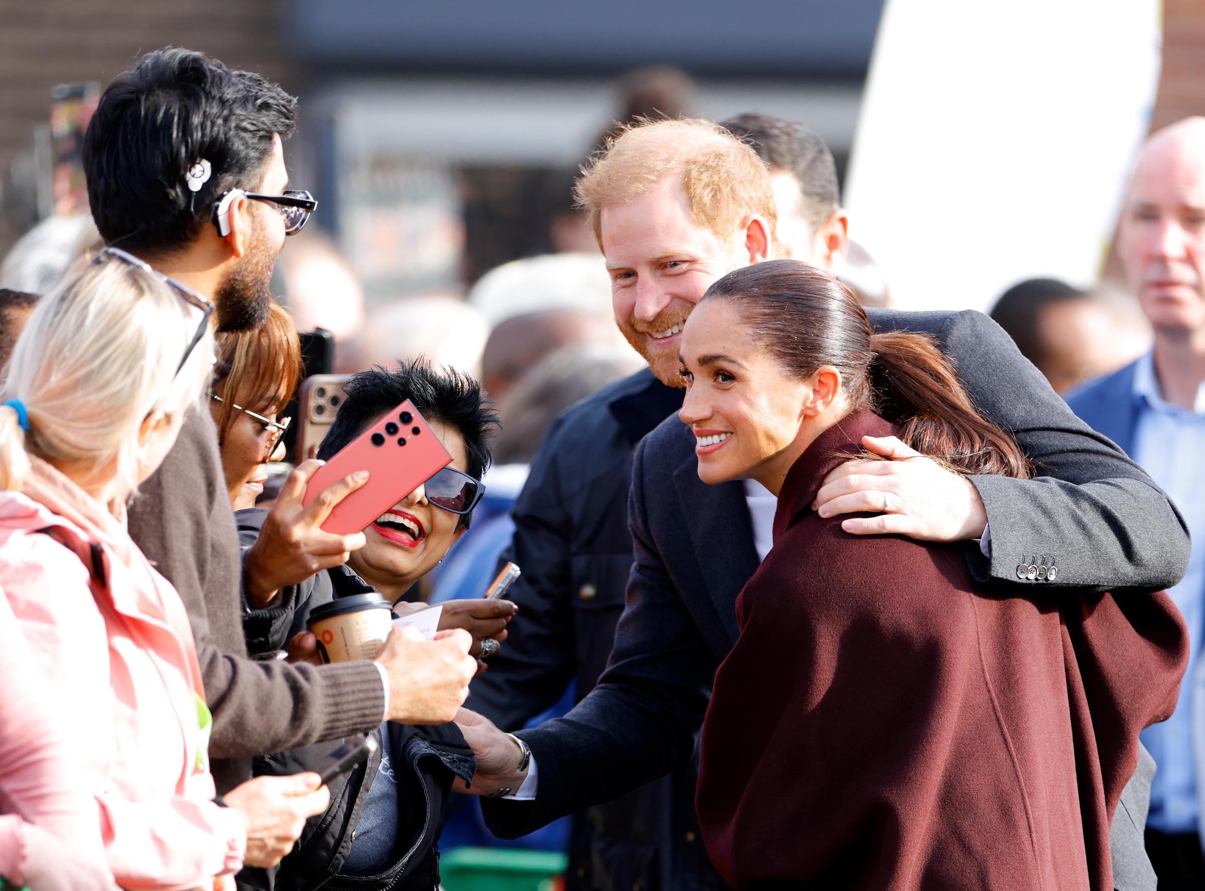 Harry paused to admire a fan's bright pink jacket and chatted with a young child along the ropes. | Source: Getty Images