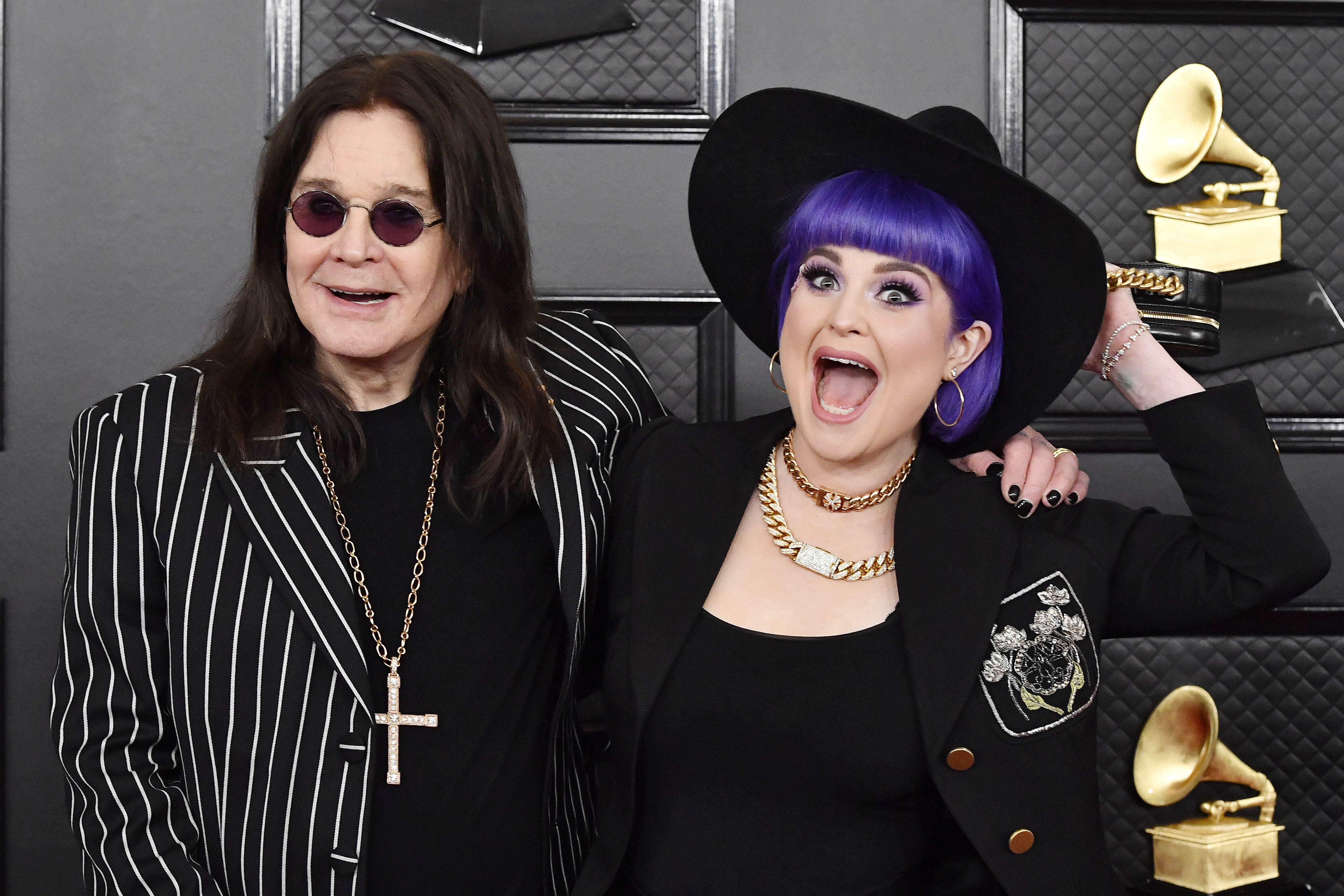 Ozzy Osbourne and his daughter Kelly shared a joyful moment at the 2020 Grammy Awards, with Kelly playfully posing beside her father in a wide-brimmed hat and bright purple hair. | Source: Getty Images