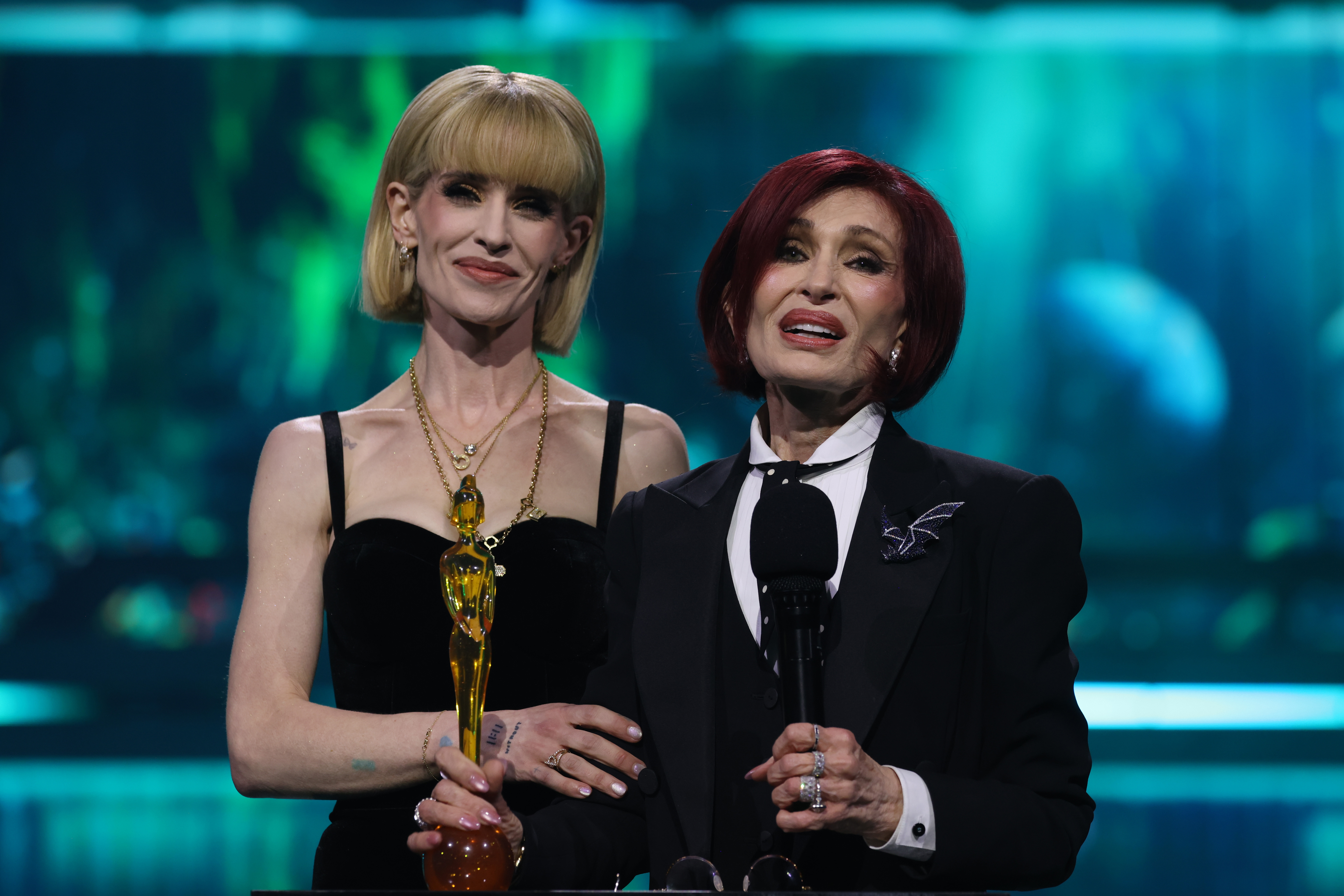 Kelly Osbourne stood beside her mother, Sharon, as they accepted Ozzy Osbourne’s posthumous Lifetime Achievement Award at the 2026 BRIT Awards, honoring the late rock legend just seven months after his death. | Source: Getty Images.