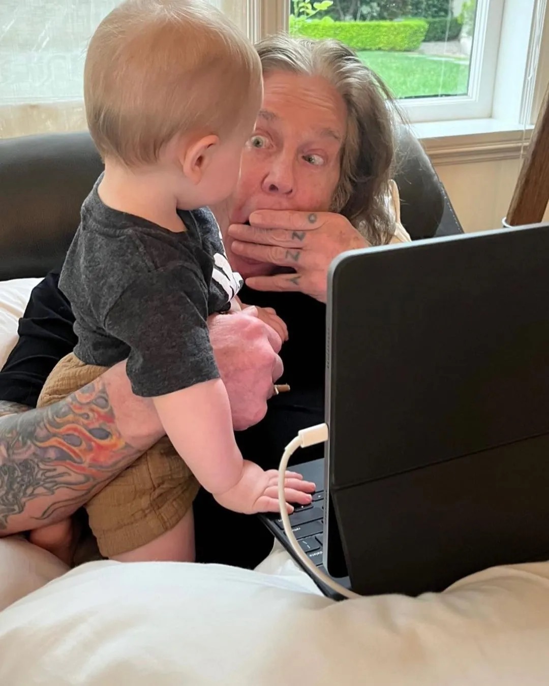 Ozzy Osbourne shared a playful moment with his grandson Sidney, making a funny face as the little boy stood on his lap. Kelly later revealed that her son had spent the first two years of his life living with his grandparents. | Source: Instagram/@sharonosbourne