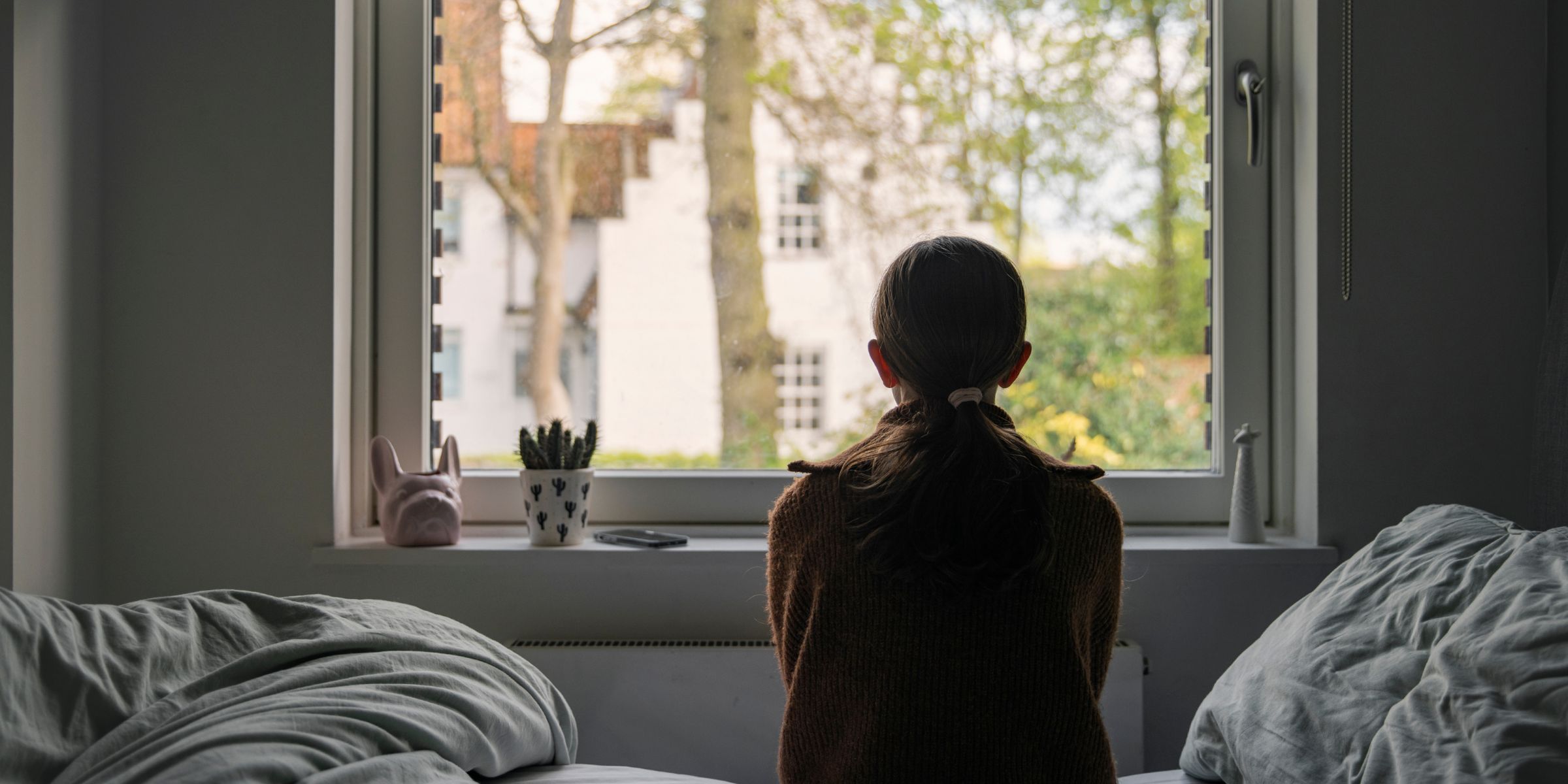 A young girl looking out of her bedroom window | Source: Getty Images