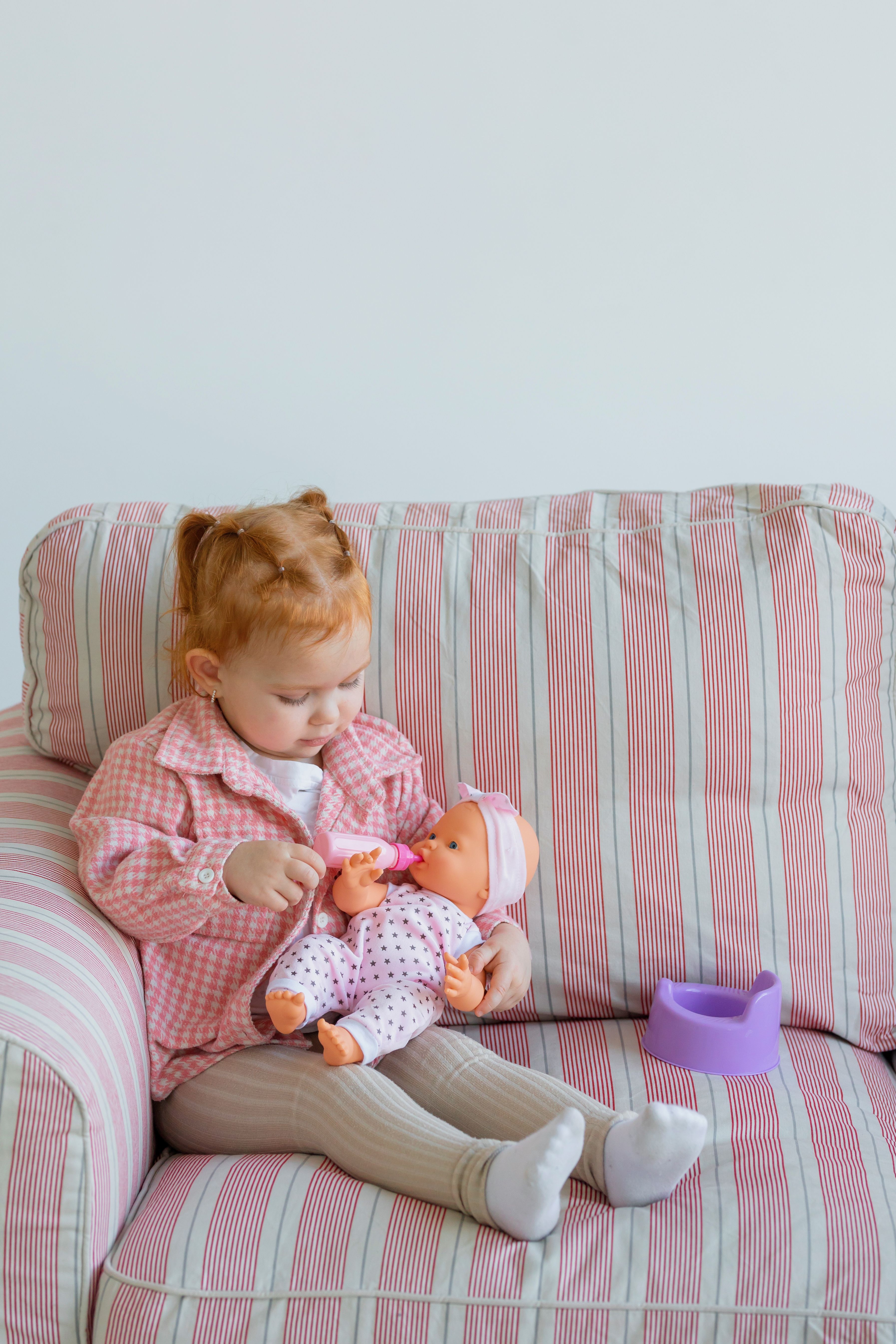 A toddler caring for her doll | Source: Pexels