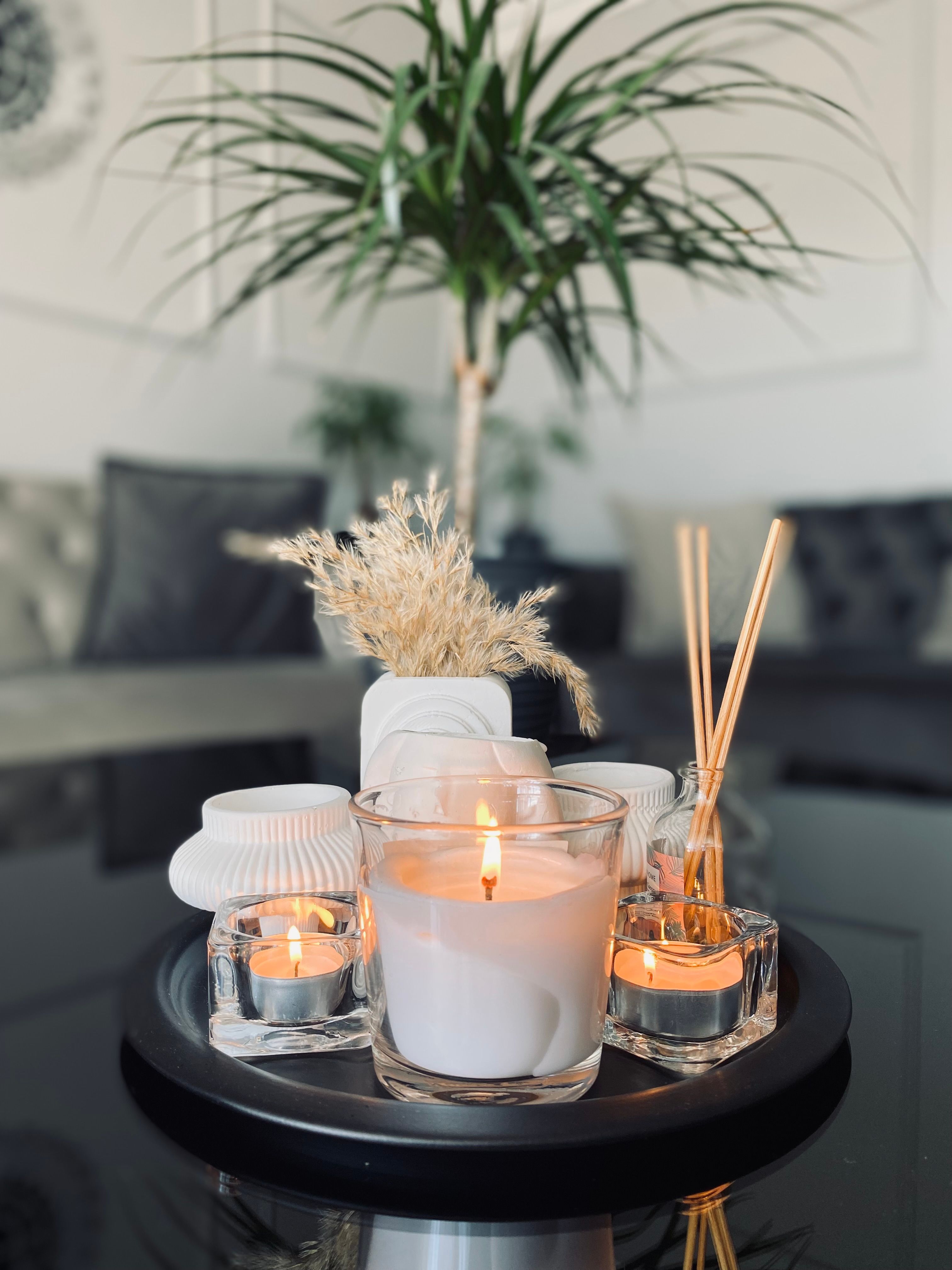 A decorative tray with lit candles, a reed diffuser, and dried flowers. | Source: Pexels