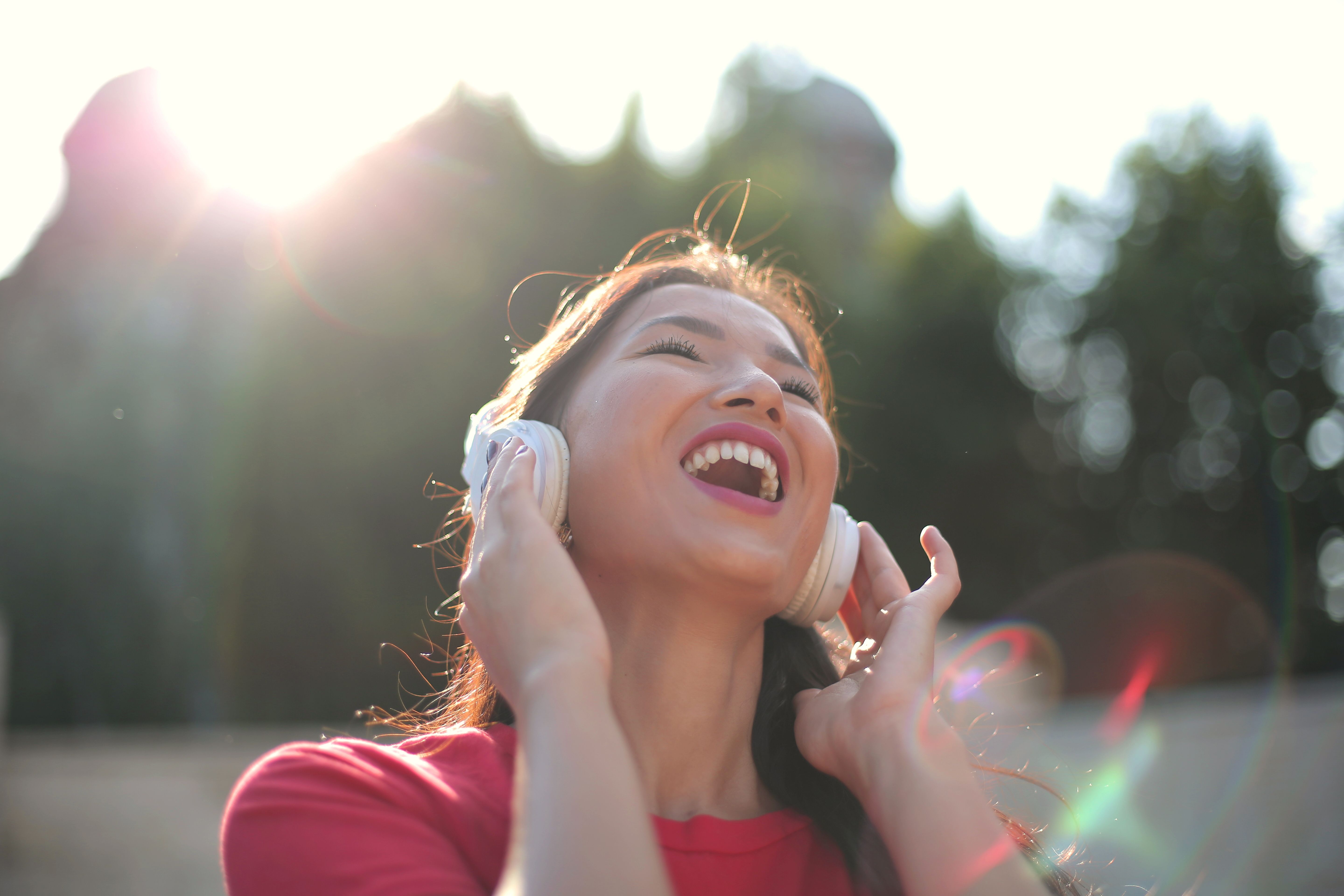 A woman throws her head back in delight as she listens to music | Source: Pexels