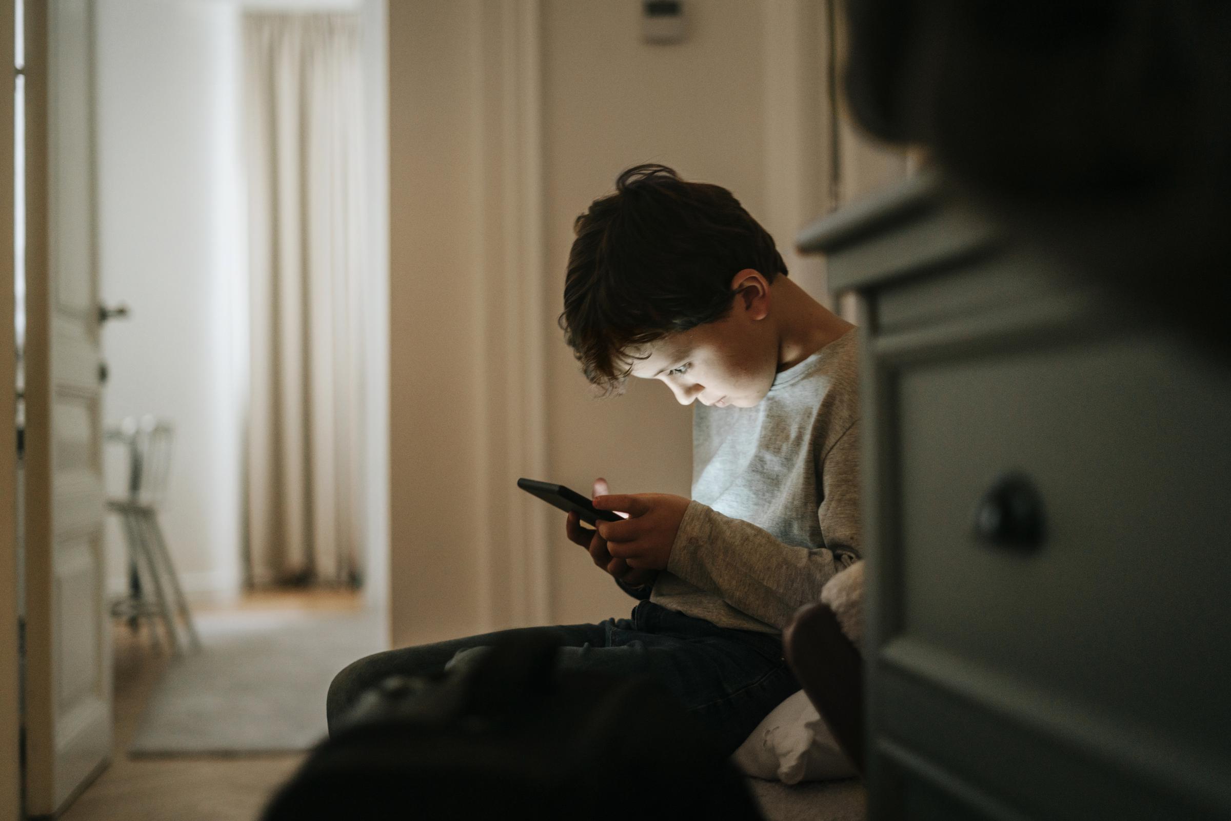A young boy playing video games on his phone | Source: Getty Images