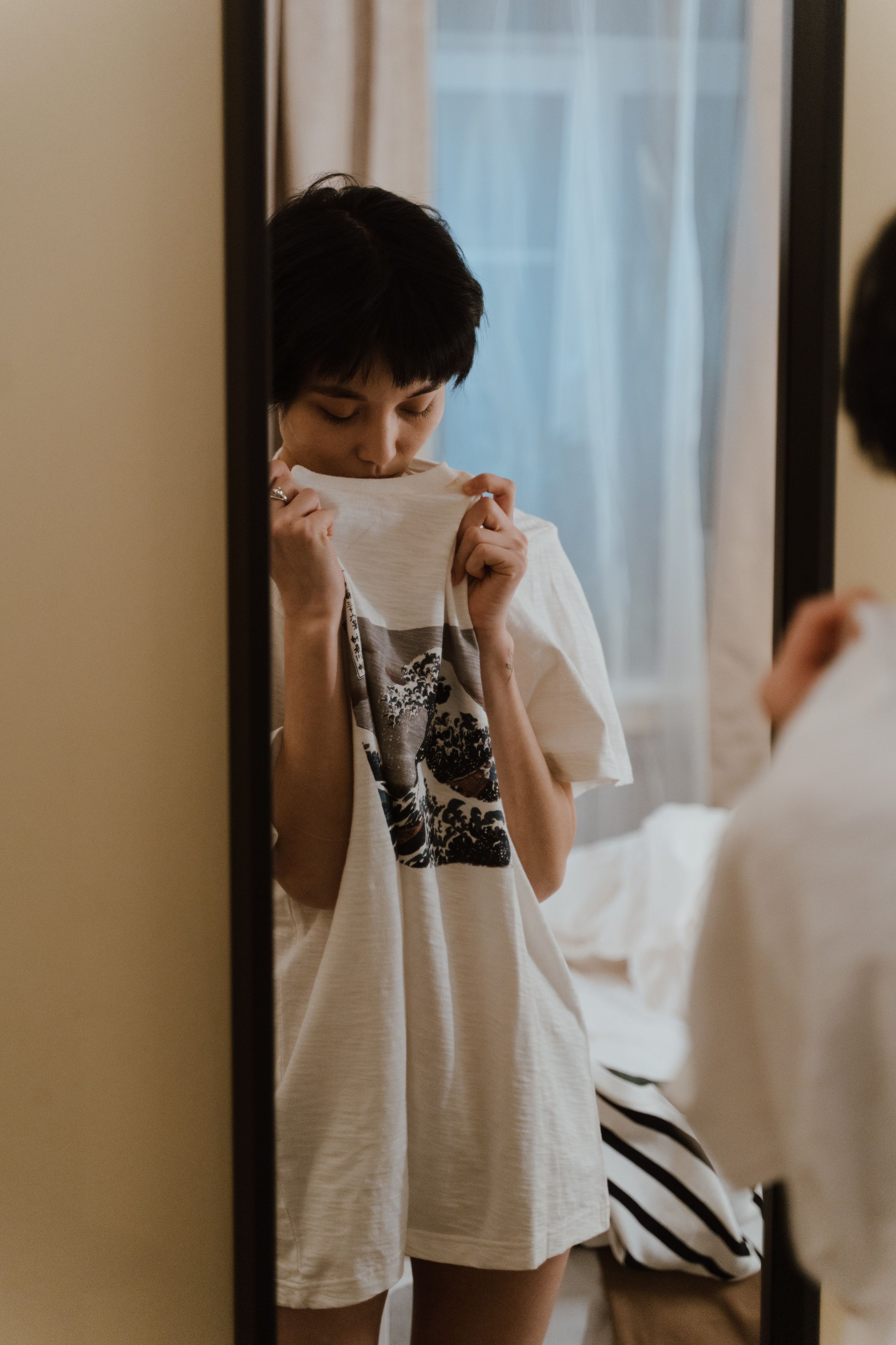 A woman peeking through her shirt in front of a mirror | Source: Pexels