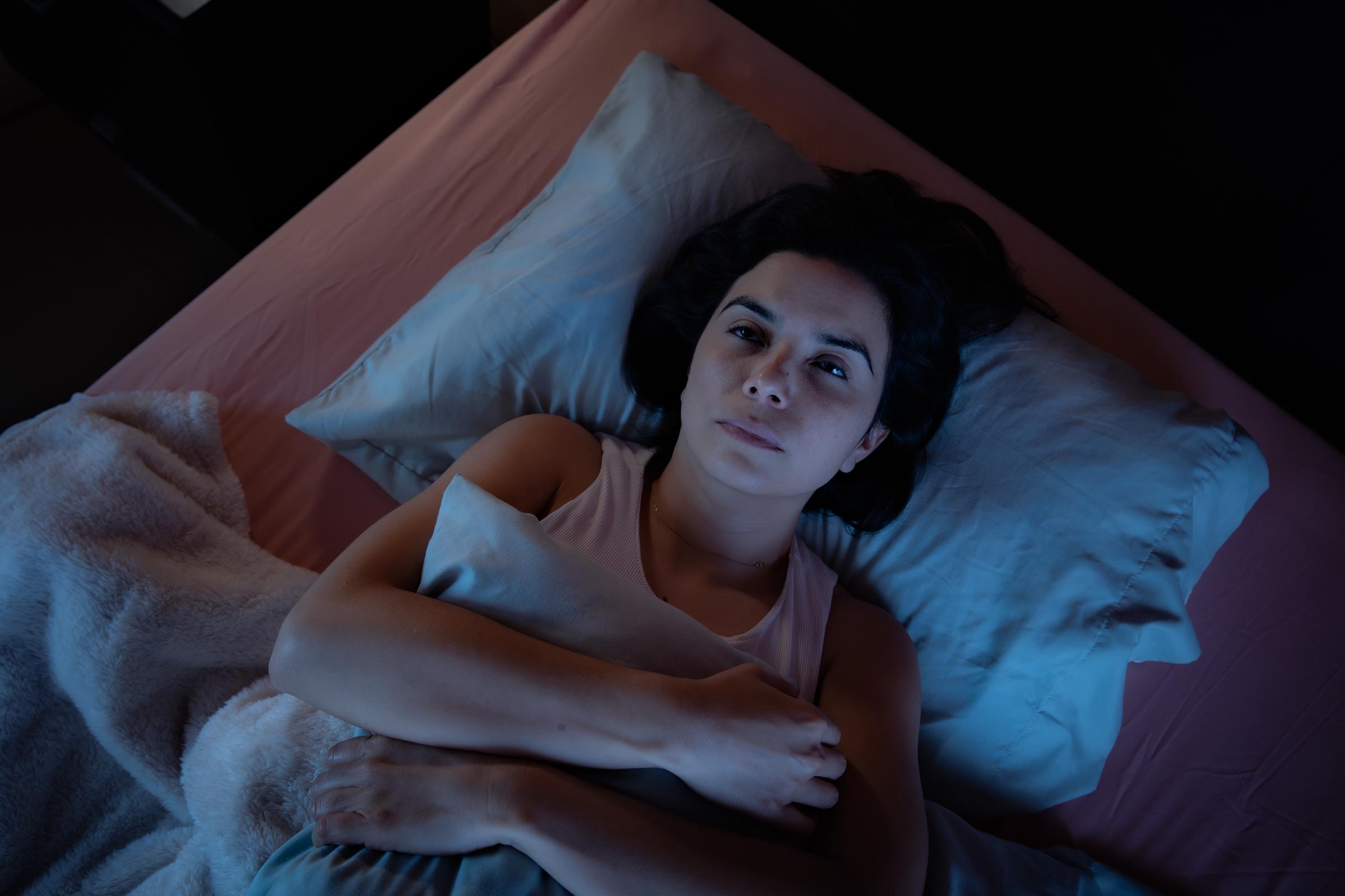 A woman lying awake in bed at night | Source: Getty Images