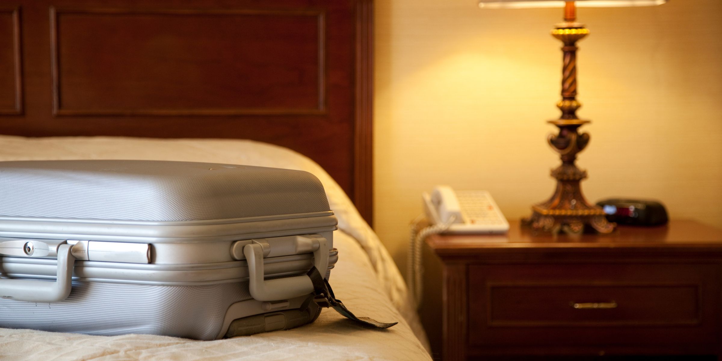 A suitcase on a bed in a hotel room | Source: Getty Images