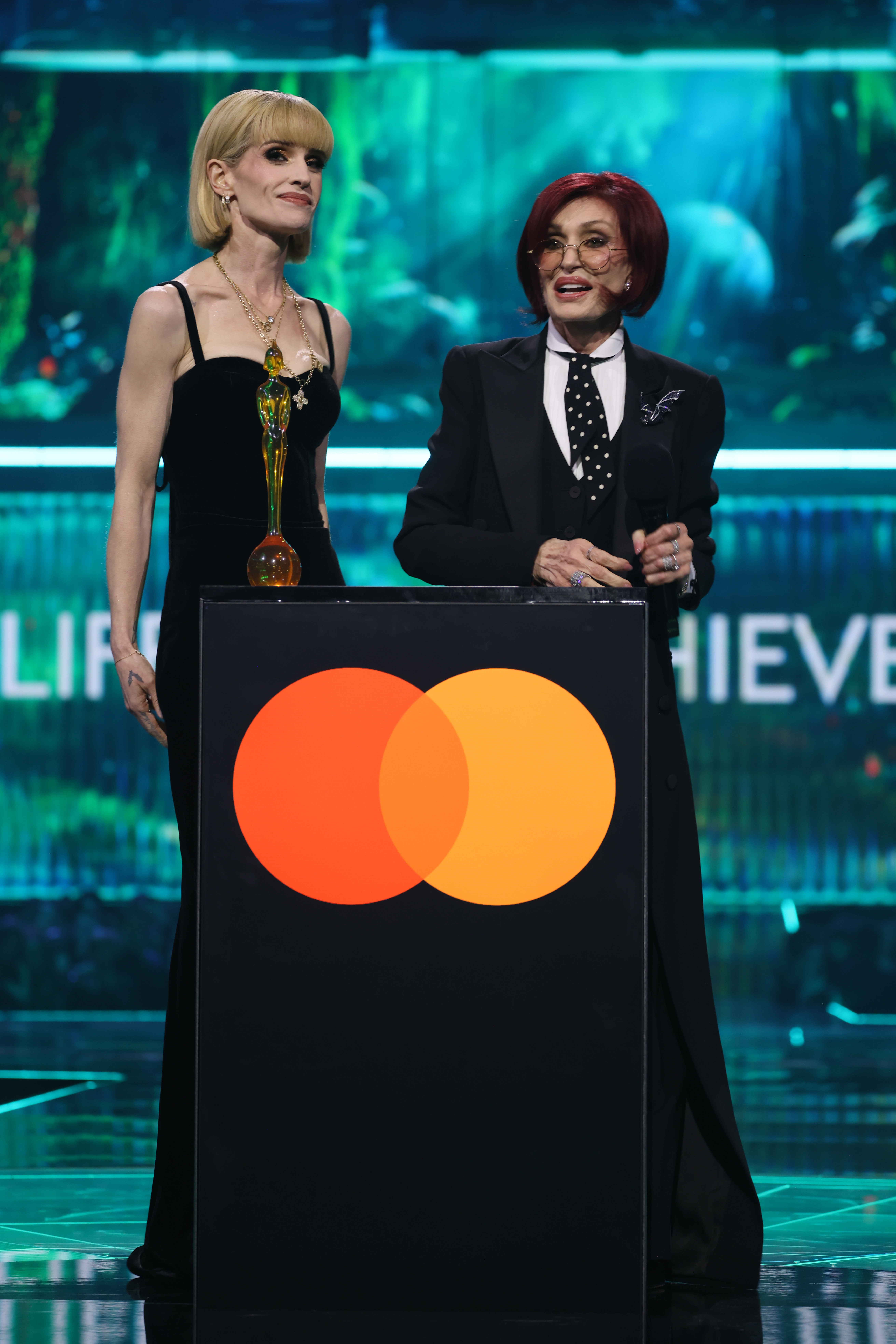 Sharon Osbourne addressed the audience at the 2026 BRIT Awards while Kelly stood beside her, listening as they honored Ozzy's legacy and accepted his posthumous Lifetime Achievement Award. | Source: Getty Images.