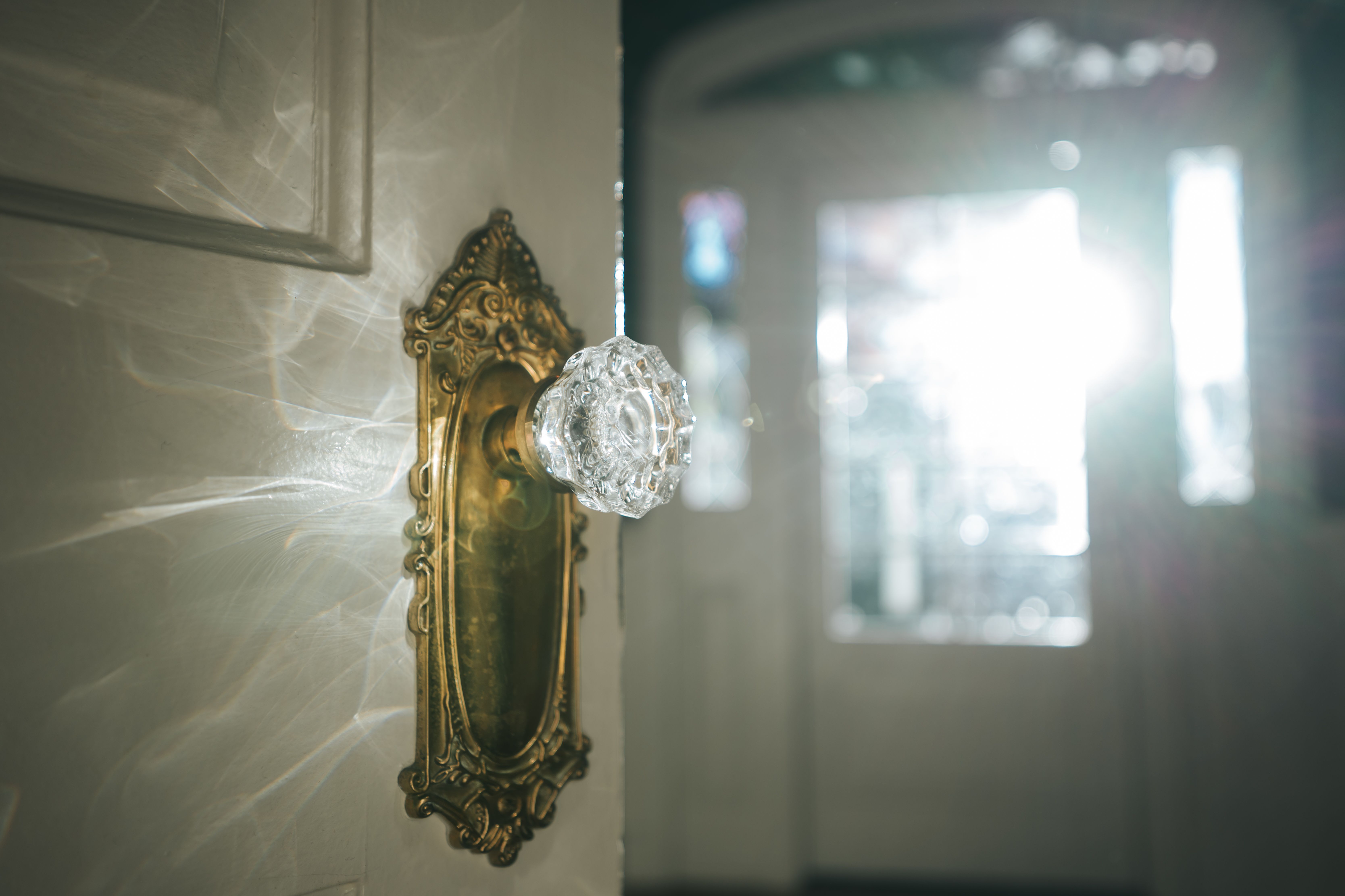 A vintage glass doorknob with an ornate brass backplate. | Source: Pexels