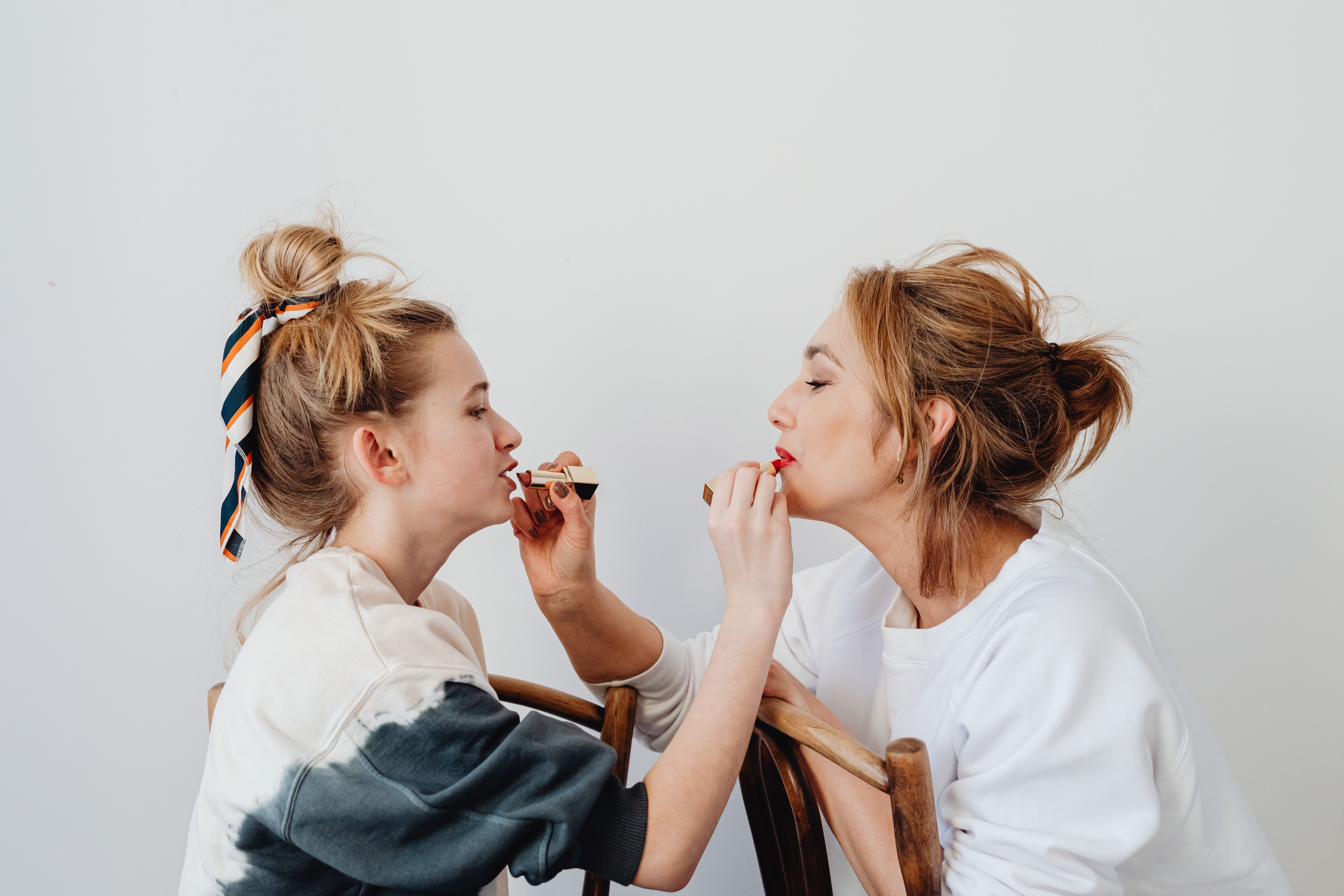 Two women applying lipstick on each other | Source: Pexels
