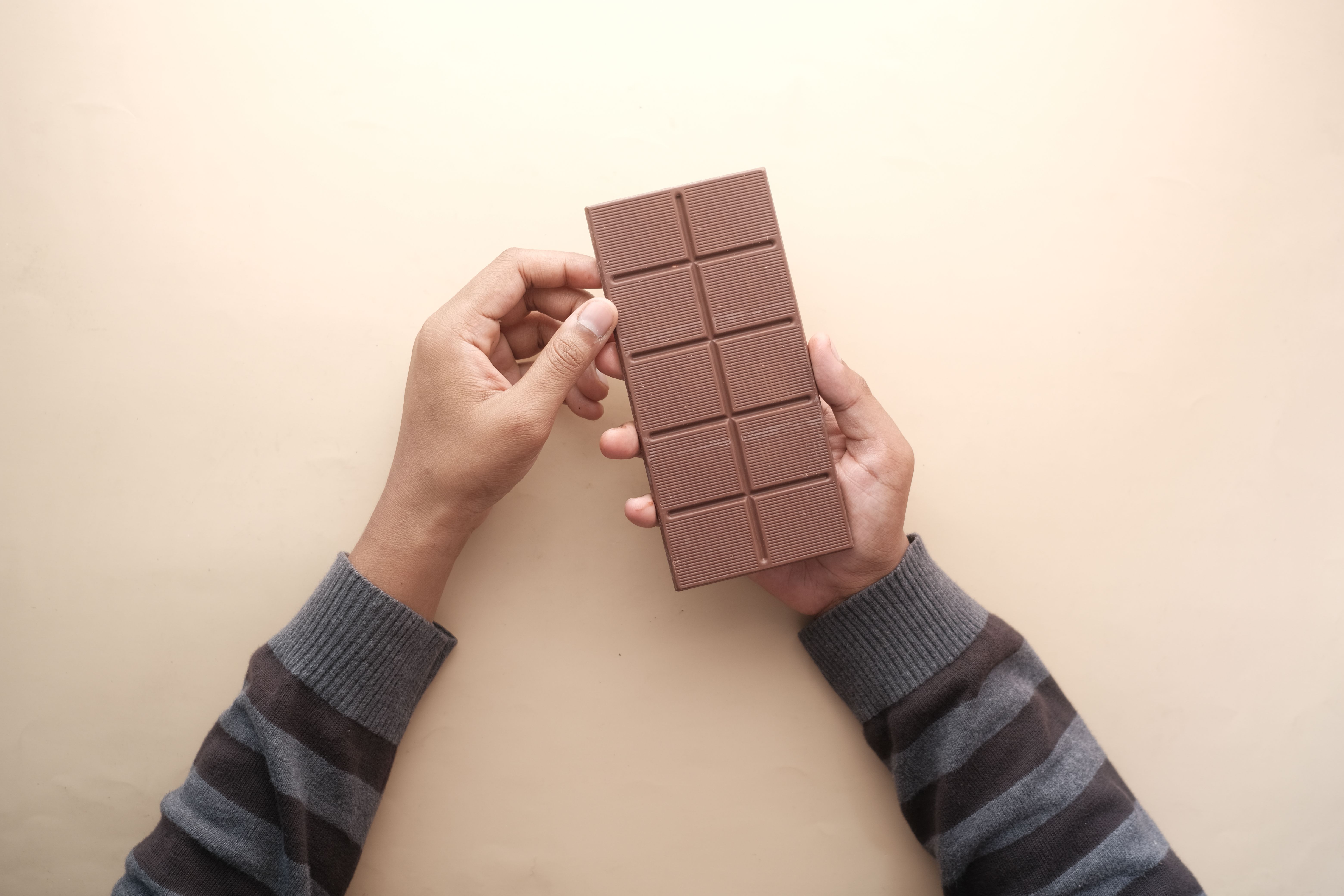 A person's hands holding a candy bar | Source: Pexels