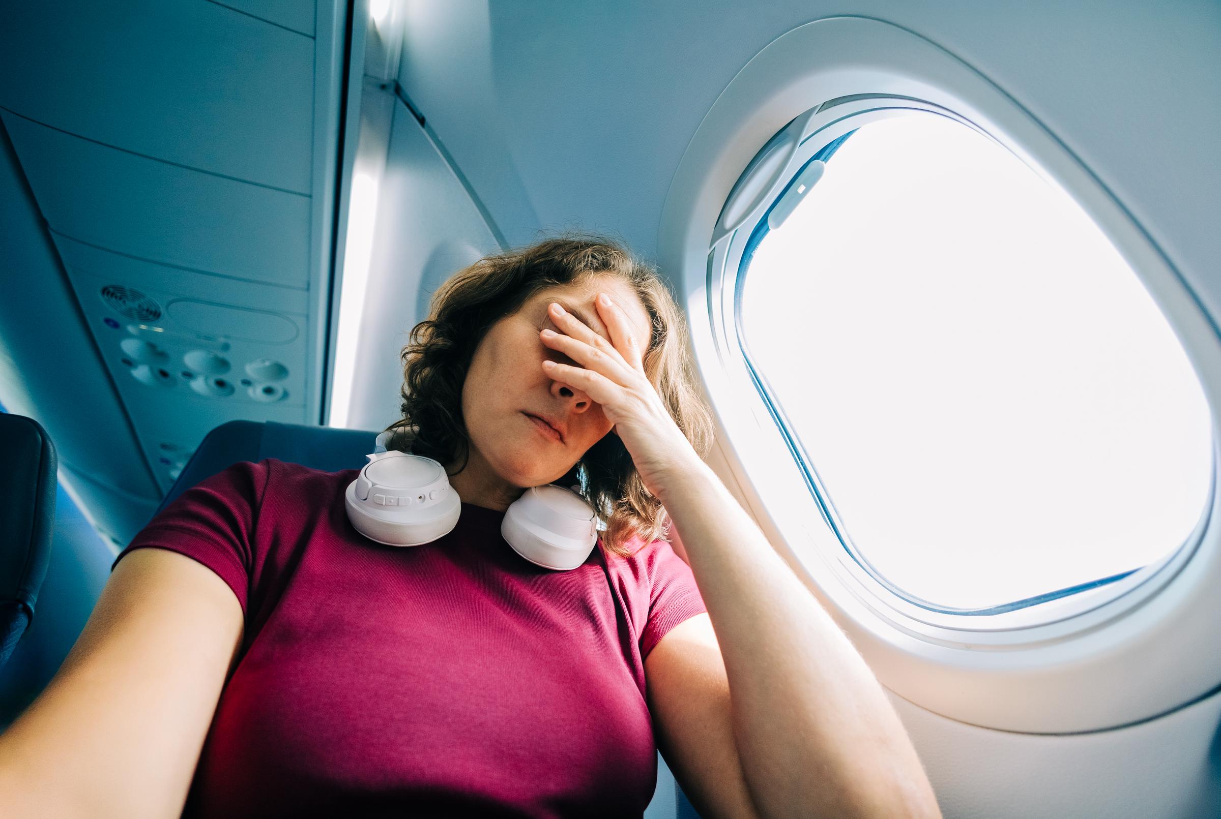 A woman feeling stressed on a plane | Source: Getty Images